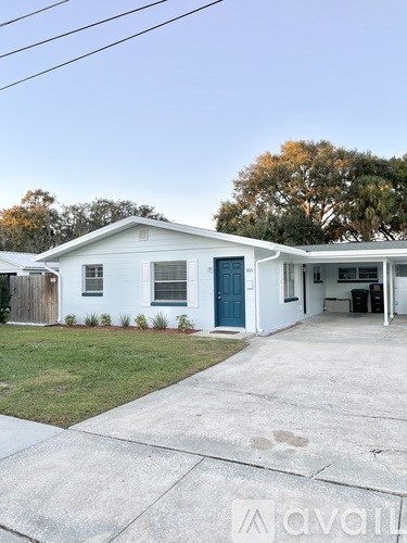 A white house with a blue door is for sale.
