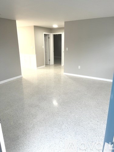A long, empty hallway with a door at the end.