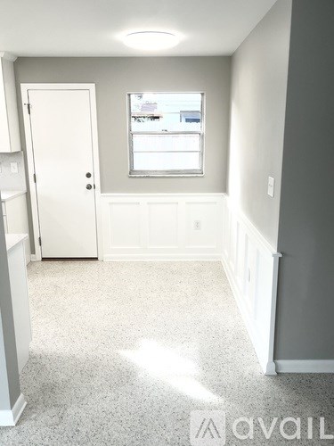 A room with a door, window, and a carpeted floor.