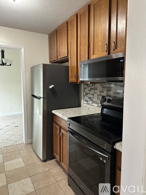 A kitchen with brown cabinets and white appliances.