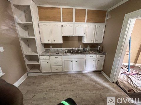 A kitchen with white cabinets and a countertop is shown.