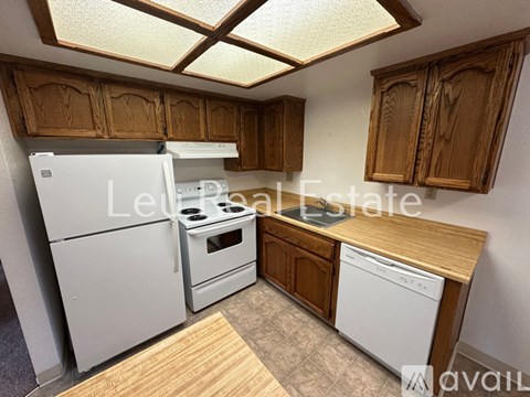 A kitchen with wooden cabinets and a white dishwasher.