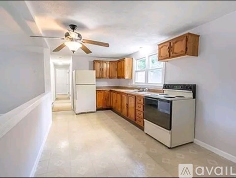 A kitchen with white appliances and wooden cabinets.