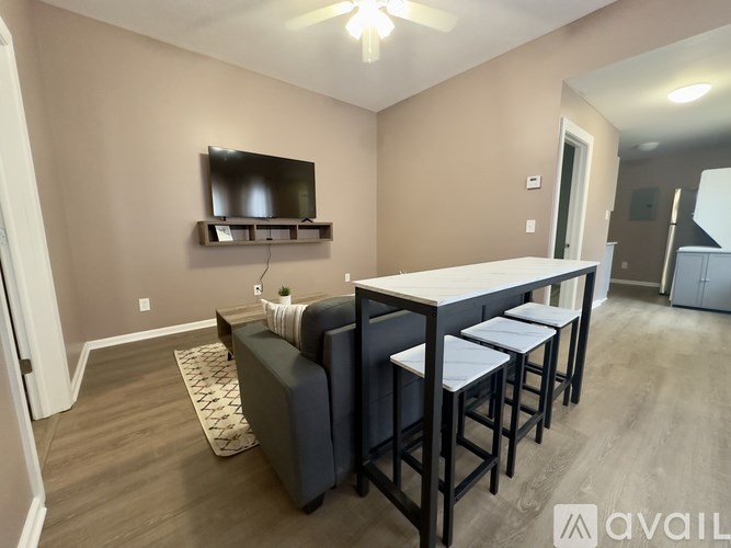 A living room with a couch, a television, and a bar area.
