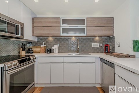 A modern kitchen with white cabinets and a stainless steel dishwasher.