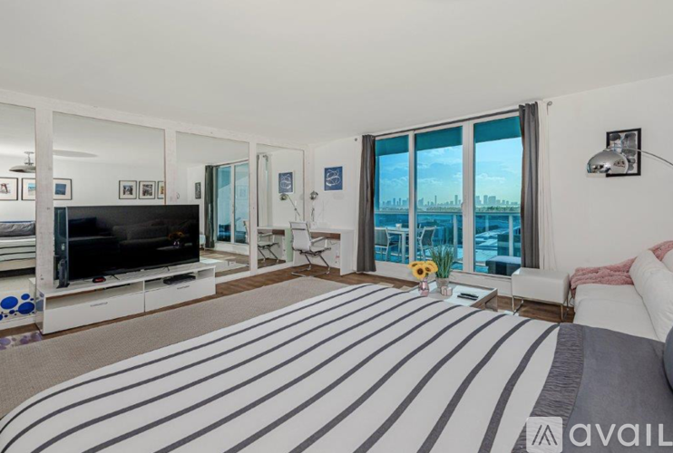 A living room with a striped carpet and a flat screen TV.