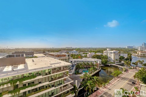 A modern building with a pool is seen from a high vantage point.
