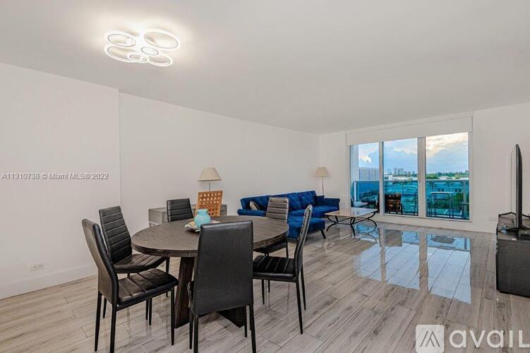 A modern dining room with a glass table and chairs.