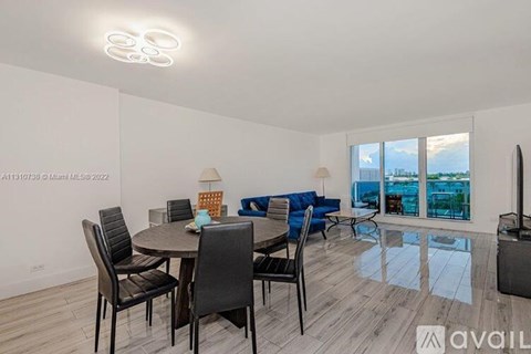 A modern dining room with a glass table and chairs.