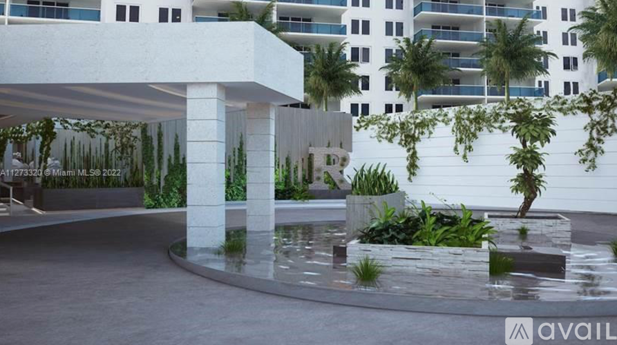 A white building with a pool in front of it.