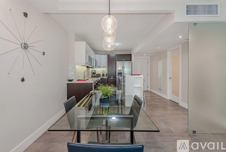 A modern dining room with a glass table and chairs.