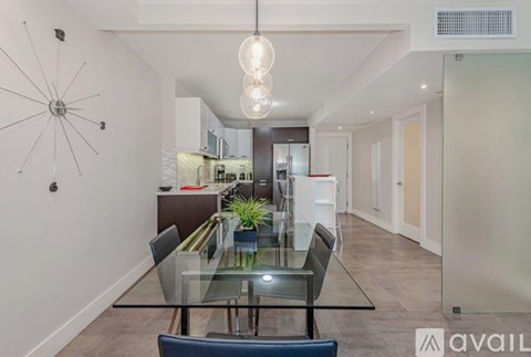 A modern dining room with a glass table and chairs.