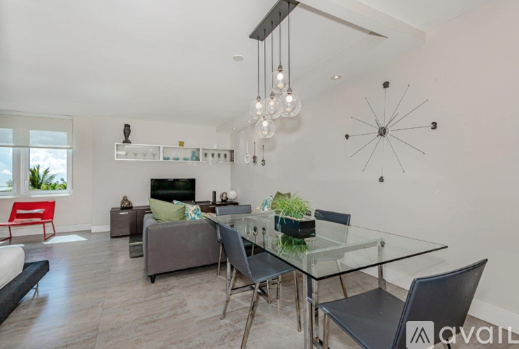 A modern living room with a glass dining table and chairs.