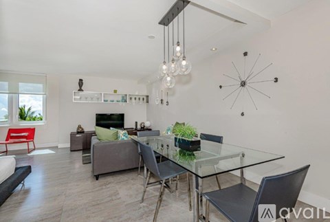 A modern living room with a glass dining table and chairs.