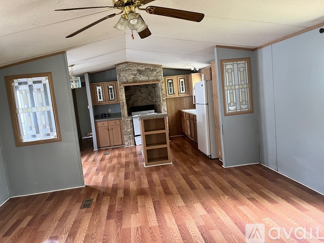A room with a ceiling fan and wooden flooring.