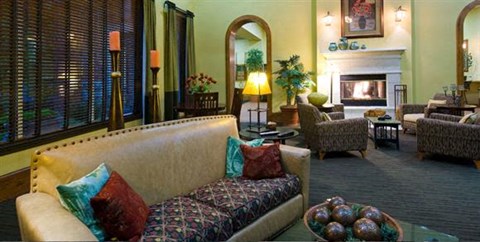 A cozy living room with a couch, chairs, and a fireplace.