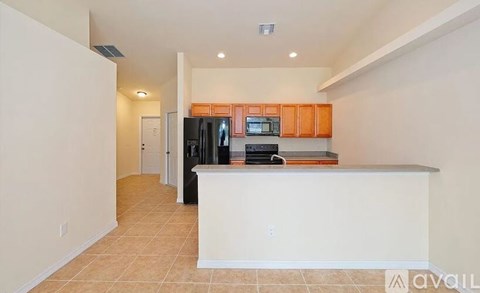 A kitchen with a white counter and orange cabinets.