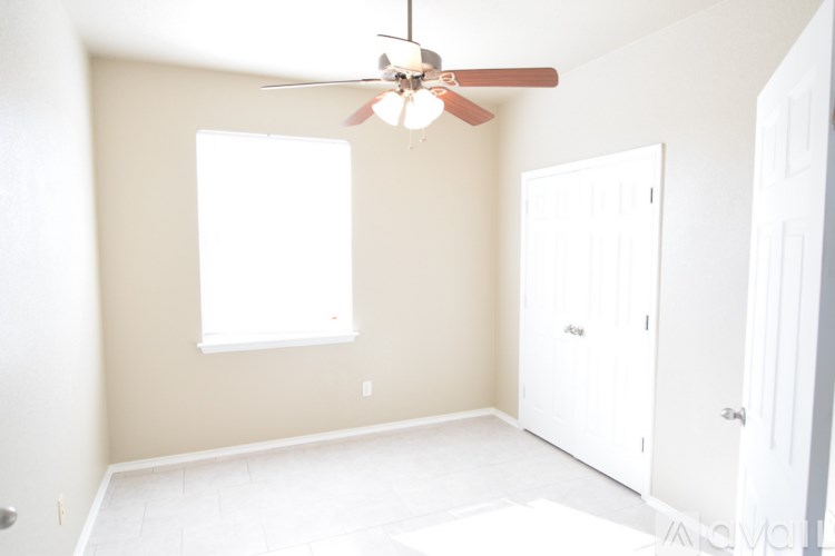 A spacious room with a fan and tiled floor.