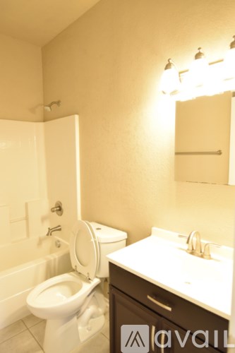 A bathroom with a toilet, sink, and mirror.