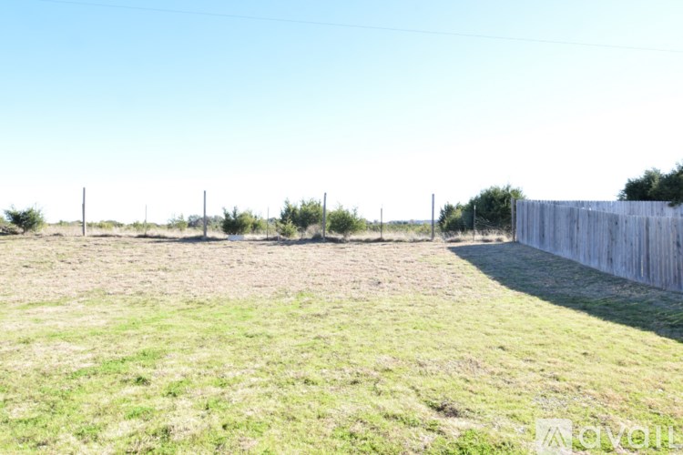 A field with a wooden fence on the right side.
