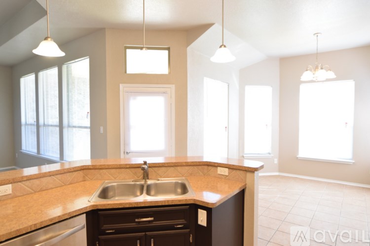 A kitchen with a granite countertop and stainless steel appliances.