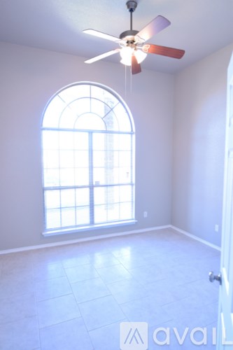 A room with a ceiling fan and a window.