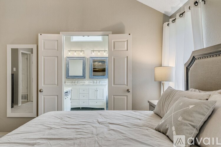 A bedroom with a large bed and a mirrored closet door.