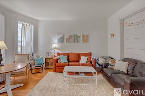 A living room with a brown leather couch and a white coffee table.