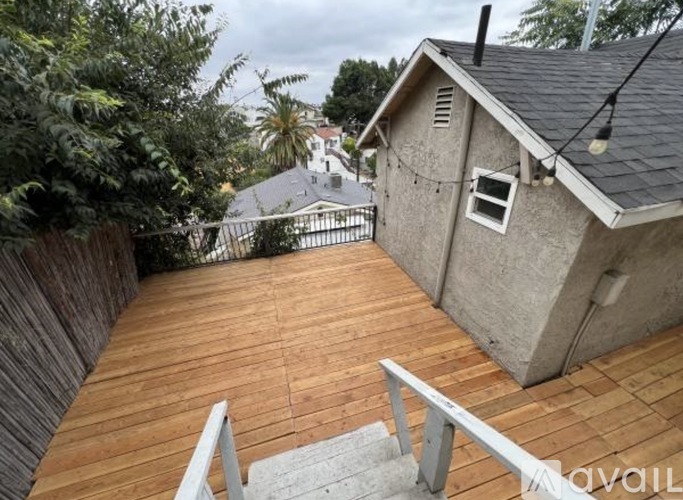 A patio with a table, chairs, and a bench is set up on a balcony.
