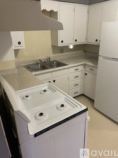 A white kitchen with a dishwasher in the foreground.
