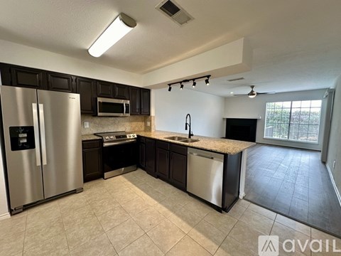 A kitchen with a refrigerator, microwave, and sink.