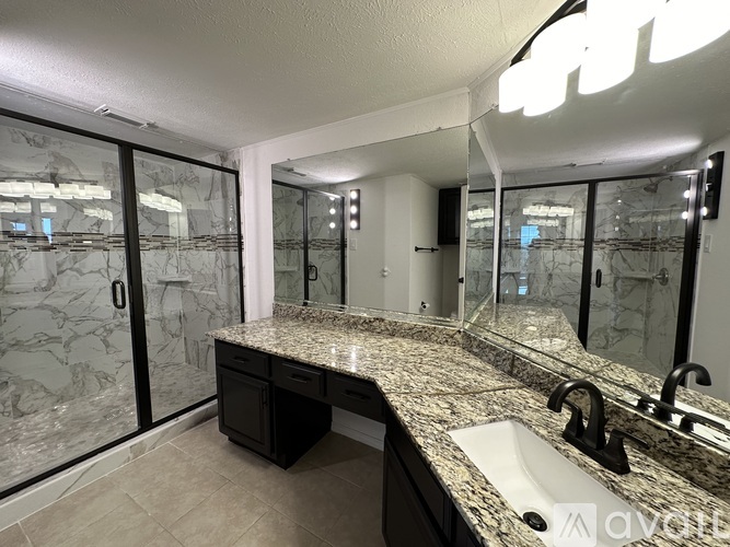 A bathroom with a marble countertop and a sink.