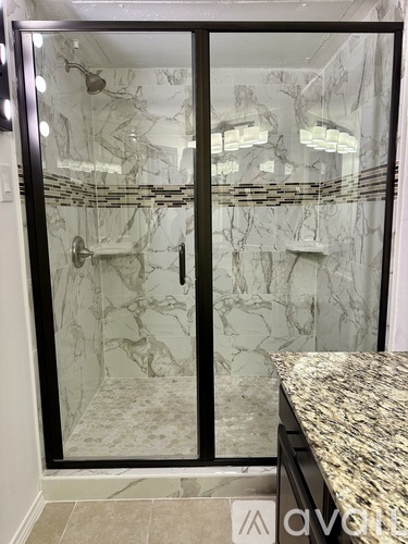 A marble bathroom with a walk-in shower and a marble countertop.