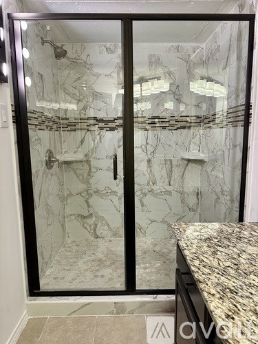 A marble bathroom with a walk-in shower and a marble countertop.