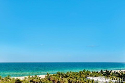 A beach with a clear blue sky and turquoise water.