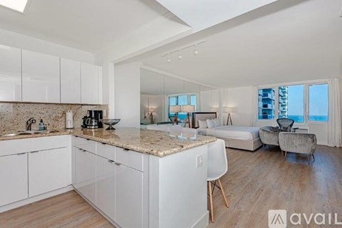 A modern kitchen with white cabinets and a marble countertop.