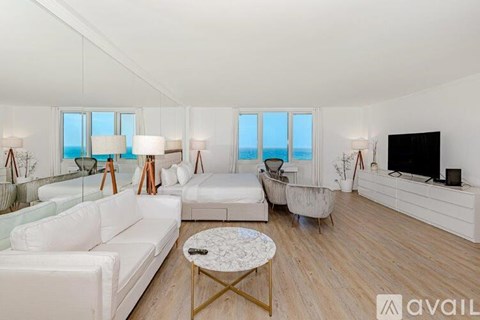 A living room with white furniture and a flat screen TV.