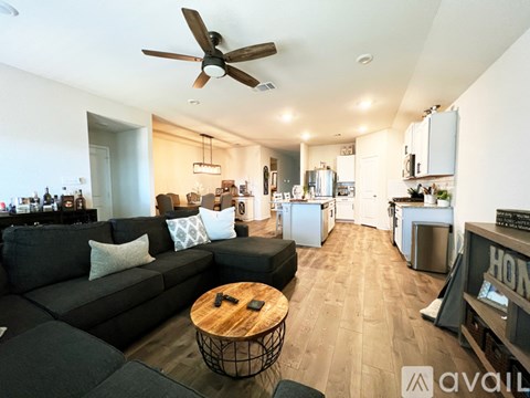A living room with a black couch and a wooden coffee table.