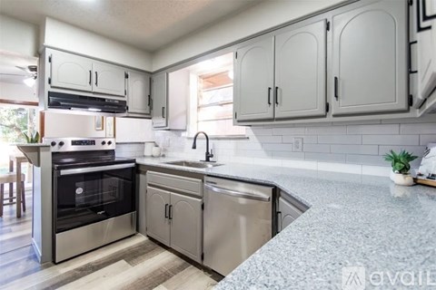 A kitchen with a granite countertop and stainless steel appliances.