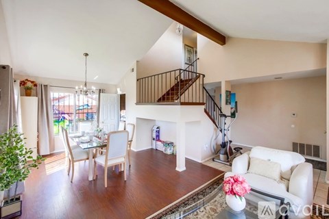 A living room with a white couch and a wooden floor.