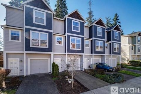 A row of townhouses with a car parked in the driveway.