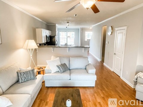 A living room with a white couch and a wooden floor.