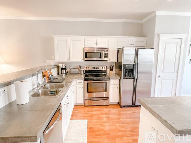 A kitchen with white cabinets and stainless steel appliances.