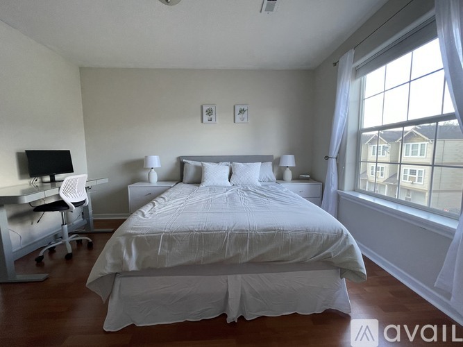 A bedroom with a large bed and a desk with a computer.