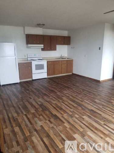 A kitchen with wooden floors and white appliances.