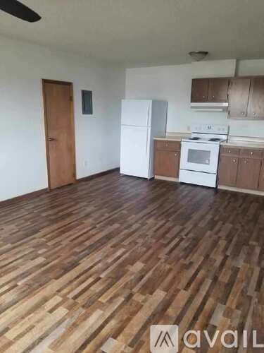 A kitchen with wooden floors and white appliances.