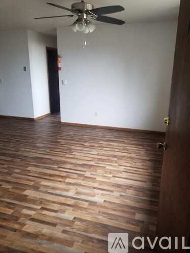 A room with wooden flooring and a ceiling fan.