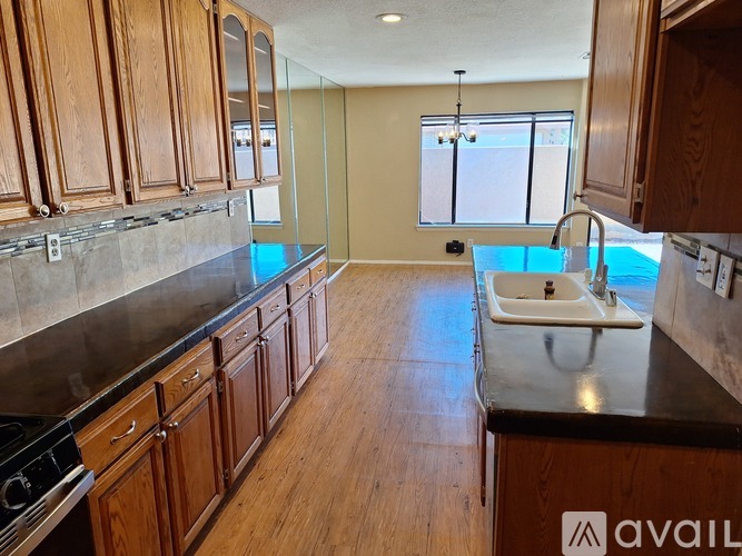 A kitchen with wooden cabinets and a black countertop.