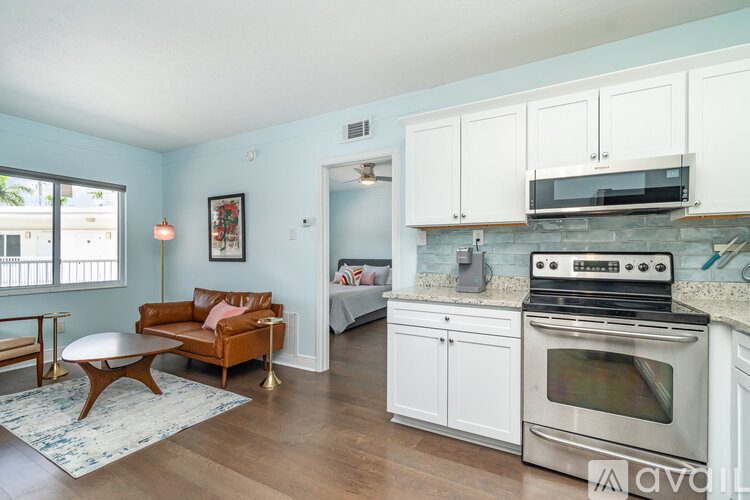 A kitchen with a stove top oven and white cabinets.