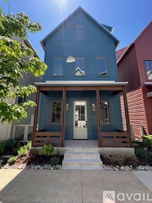 A blue house with a white door and windows.